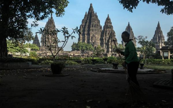 Pekerja menyapu kawasan wisata Candi Prambanan Minggu (20/6/2021). (Foto : Antara)