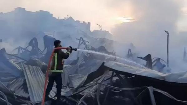 PASAR LELES TERBAKAR1 Petugas dari Dinas Pemadam Kebakaran Kabupaten Garut melakukan pendinginan menyemprotkan air ke sejumlah titik di Pasar Leles yang terbakar. (Foto: iNews/Ii Solihin)