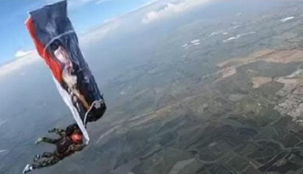 Prajurit TNI AL terjun payung dari pesawat membentang foto Presiden Jokowi. (Foto Instagram TNI AL).