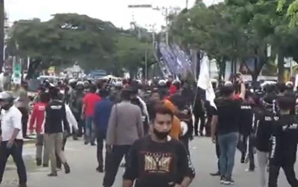 Demo ricuh 2 Petugas Polda Sultra menghalau aksi demonstrasi mahasiswa menolak kedatangan Presiden Jokowi di Kota Kendari, Rabu (30/6/2021). (Foto: MNC Portal/Febriyono Tamenk)