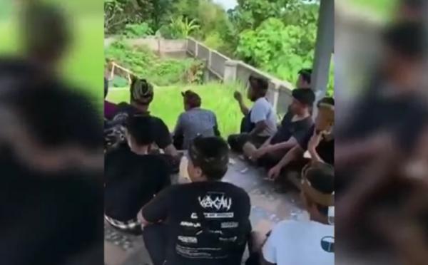 Tangkapan layar sekelompok warga Gianyar mencemooh petugas yang sedang memakamkan jenazah Covid-19 di kuburan adat.