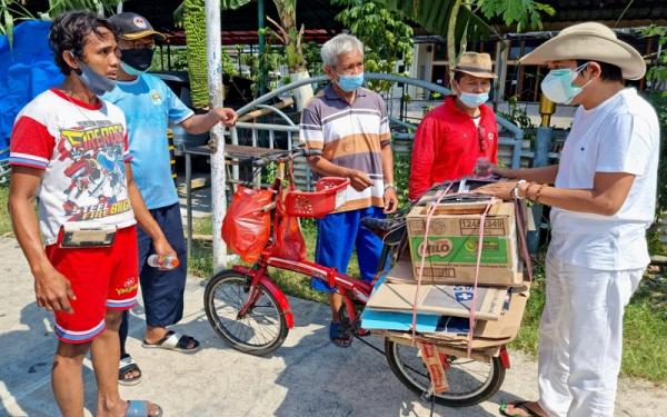 Arif menunjukkan sepeda yang digunakannya untuk memulung kardus. Di sepeda itu terdapat kotak untuk menabung uang. Setelah terkumpul, uang itu dipakai untuk membeli hewan kurban. (Foto: istimewa)