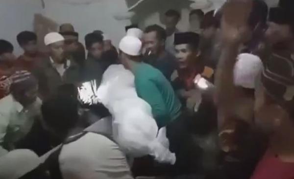 Tangkapan layar warga Desa Traktakan, WOnosari, Kabupaten Bondowoso mengambil paksa jenazah pasien Covid-19 dari dalam ambulans untuk disalatkan di masjid. (Foto: MNC Portal/Riski Amirul Ahmad)