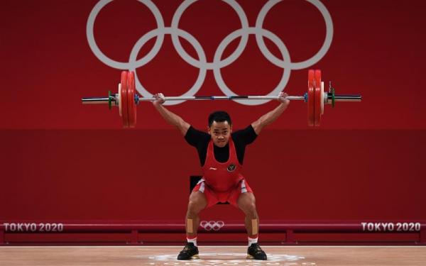 Lifter Indonesia Eko Yuli Irawan melakukan angkatan snatch dalam kelas 61 kg Putra Grup A Olimpiade Tokyo 2020 di Tokyo International Forum, Tokyo, Jepang, Minggu (25/7/2021). Eko Yuli berhasil mempersembahkan medali perak dengan total angkatan 302 k