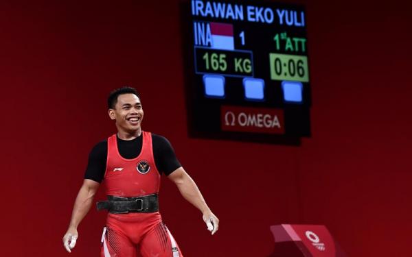 eko yuli-3 Lifter Indonesia Eko Yuli Irawan tersenyum seusai melakukan angkatan clean and jerk dalam kelas 61 kg Putra Grup A Olimpiade Tokyo 2020 di Tokyo International Forum, Tokyo, Jepang, Minggu (25/7/2021). Eko Yuli berhasil mempersembahkan medali perak de