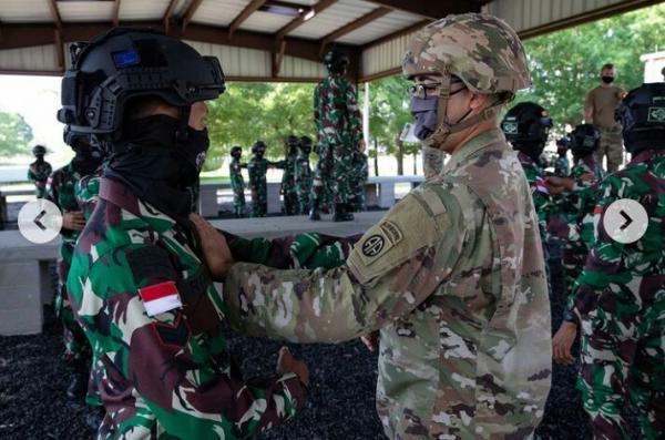 US Army memakaikan pengaman pada prajurit TNI AD sebelum berlatih (Foto: Instagram)