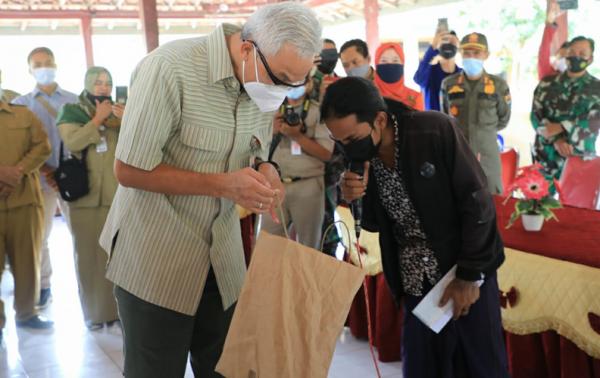 Gubernur Ganjar Pranowo meninjau penyaluran BST di Balai Desa Panunggalan, Kabupaten Grobogan. Selasa (3/8). (foto: Istimewa)