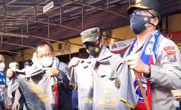 Kapolda Jatim Irjen Pol Nico Afinta mendapat jersey kehormatan saat menyambangivaksinasi Merdeka Semeru yang diikuti seratusan Aremania memeringati Ulang Tahun Arema FC di Mapolres Kota Malang, Rabu (11/8/2021).  (Foto: MNC Portal/Deni Irwansyah)