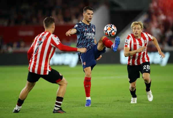 Arsenal kalah dari Brentford Granit Xhaka diapit dua pemain Brentford. Xhaka gagal mengantar Arsenal menang di laga pembuka Liga Inggris, Sabtu (14/8/2021). (Foto: REUTERS)