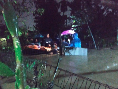 Petugas BPBD Kota Padang mengevakuasi warga yang terjebak banjir satu meter, rabu (18/8/2021). Banjir terjadi setelah wilayah itu diguyur hujan lebat. (Foto: MNC Portal/Rus Akbar)