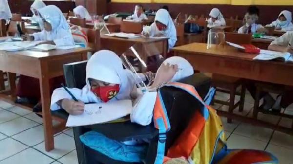 Kembar siam Al Putri Dewi dan Al Putri Anugrah belajar di kelas. (Foto: iNews/Ii Solihin)