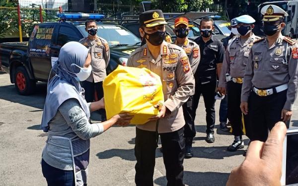 Kapolrestabes Bandung Kombes Pol Aswin Sipayung yang merupakan alumnus Akpol 93 memberikan paket sembako kepada PKL. (Foto: iNews.id/Agus Warsudi)