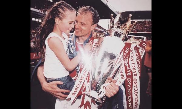 Dennis Bergkamp mengajak Estelle ke tengah lapangan saat Arsenal meraih trofi Liga Inggris. (foto: The Sun)