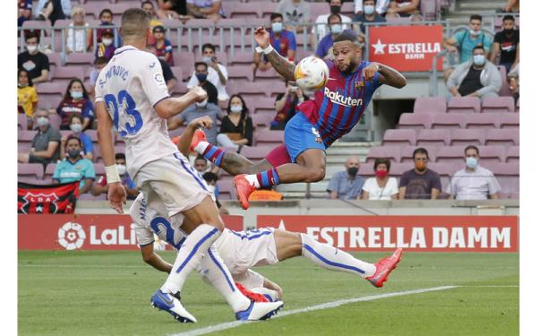 Memphis Depay Barcelona vs Getafe Penyerang Barcelona, Memphis Depay,  berusaha menghindar dari hadangan pemain Getafe dalam laga Liga Spanyol di Stadion Camp Nou, Minggu (29/8/2021). (Foto: REUTERS/Nacho Doce)