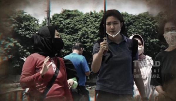 Ajudan atau ADC Ibu Pangdam II/Sriwijaya Serda (K) Intan Indah Lestari memayungi Shinta Agus Suhardi. (Foto akun Youtube TNI AD).