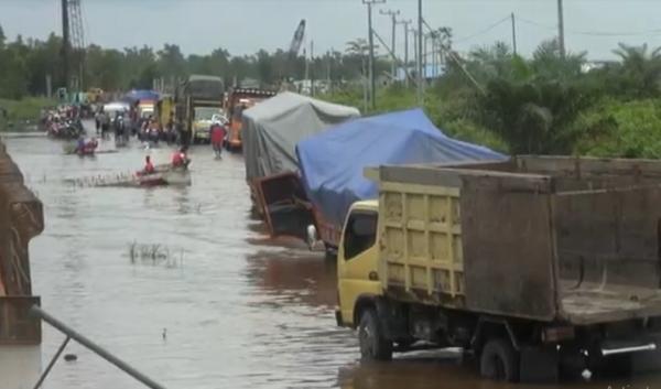 Antrean kendaraan di Jalan Trans Kalimantan poros tengah di Pulang Pisau akibat banjir. (Foto: iNews/Ade Sata)