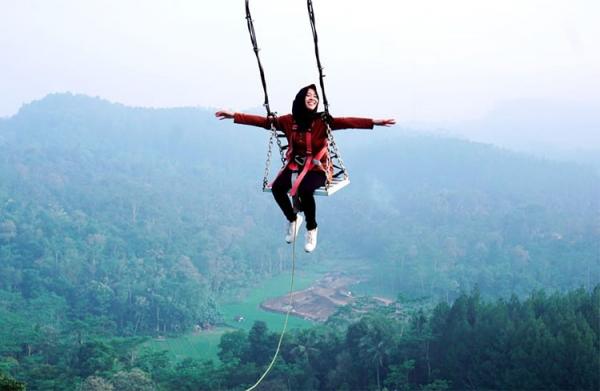 Wisatawan menikmati ayunan di atas Perbukitan Menoreh. (Foto: Dinpar Kulonprogo)