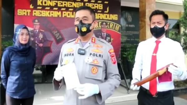 Wakapolresta Bandung AKBP Dwi Indra Laksamana dan Kasatreskrim Kompol Bintoro menunjukkan golok yang digunakan pelaku SU untuk membegal dengan modus COD. (Foto: Humas Polresta Bandung)