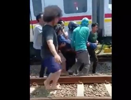 Warga mengevakuasi pemotor yang ditabrak KRL di Stasiun Rangkasbitung, Lebak. (Foto: MNC Portal/Iskandar Nasution)