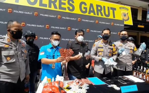 Kapolres Garut AKBP WIdhanto Hadicaksono (dua dari kanan) menunjukkan barang bukti obat terlarang yang disita dari tersangka penjual. (Foto: iNews/II SOLIHIN)