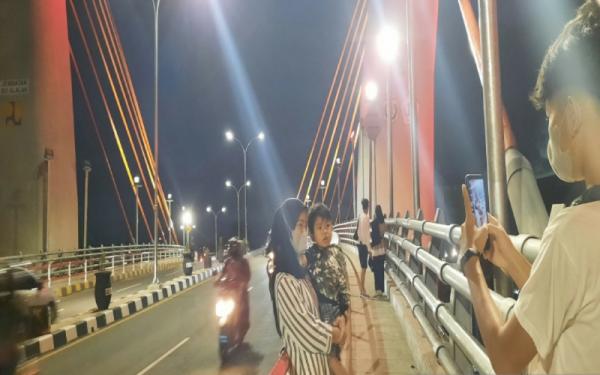 Warga berfoto di atas Jembatan Sei Alalak di Kalsel (Foto: Antara/Firman)
