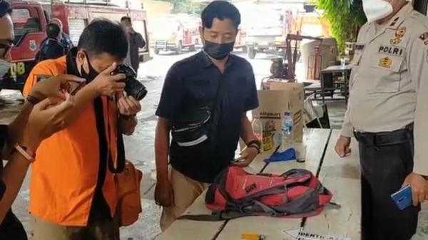 Petugas Inafis Polres Cimahi mendokumentasikan barang bukti korek api gas, tas merah, dan botol berisi siswa pertalite yang diduga milik tersangka AK. (FOTO: iNews/YUWONO WAHYU)