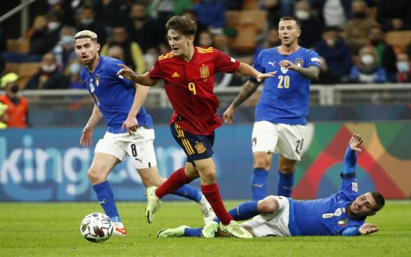 Pilar Timnas Spanyol, Gavi beraksi di antara pemain Italia Jorginho, Federico Bernardeschi, dan Marco Verratti dalam semifinal UEFA Nations League di Stadion San Siro, Kamis (7/10/2021). (Foto: REUTERS/Alessandro Garofalo)