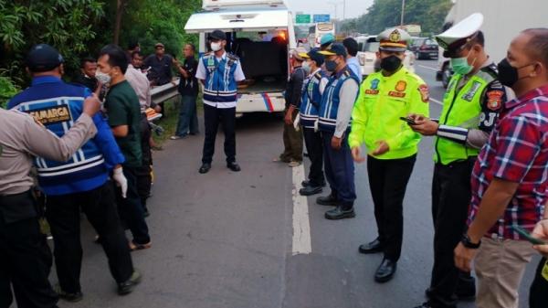 Petugas mengevakuasi sopir truk tangki yang ditemukan meninggal dunia di Tol  JORR KM 39.800 A, Jatiwarna arah Jatiasih, Bekasi, Jumat (15/10/2021). (Foto: TMC Polda Metro Jaya).
