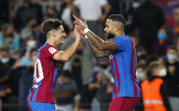 Gavi dan Memphis Depay Barcelona Penyerang Barcelona, Memphis Depay (kanan) merayakan gol ke gawang Valencia bersama Gavi dalam laga Liga Spanyol 2021/2022 di Stadion Camp Nou, Senin (18/10/2021). (Foto: REUTERS/Albert Gea)