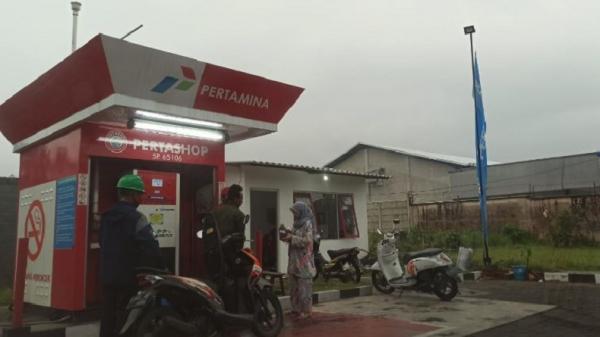 Rifki Regita, pemuda petugas Pertashop 5p.65106 Wagir saat melayani pengisian BBM kepada konsumen pengguna kendaraan. (Foto: iNews.id/Ihya Ulumuddin)