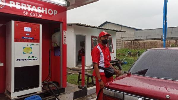 Rifki Regita, pemuda petugas Pertashop 5p.65106 Wagir saat melayani pengisian BBM kepada konsumen pengguna kendaraan. (Foto: iNews.id/Ihya Ulumuddin)