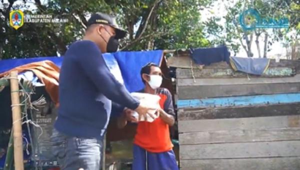 Bupati Melawi Dadi Sunarya menyerahkan bantuan logistik kepada korban banjir. (Foto: Instagram @humaspemkabmelawi)