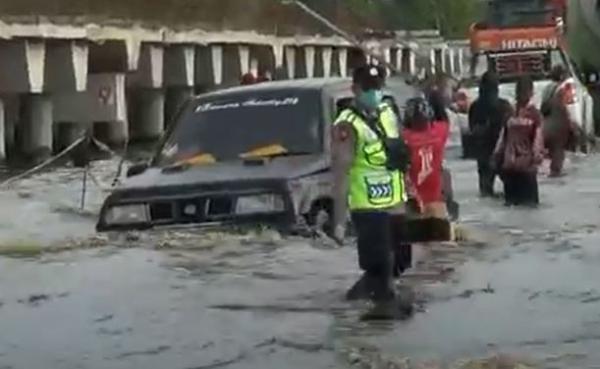 Sebuah mobil terjebak lubang di tengah kepungan banjir di Jalan Trans Kalimantan, Pulang Pisau. (Foto: iNews TV/Ade Sata)