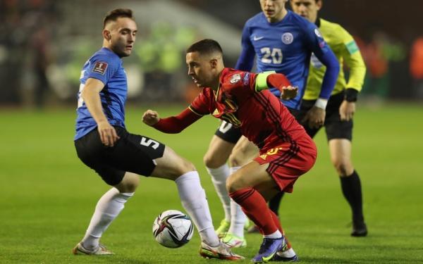 Kapten Timnas Belgia, Eden Hazard (merah) berusaha mengecoh pemain Estonia dalam laga Kualifikasi Piala Dunia 2022 di Stadion King Baudouin, Minggu (14/11/2021). (Foto: REUTERS/Pascal Rossignol)