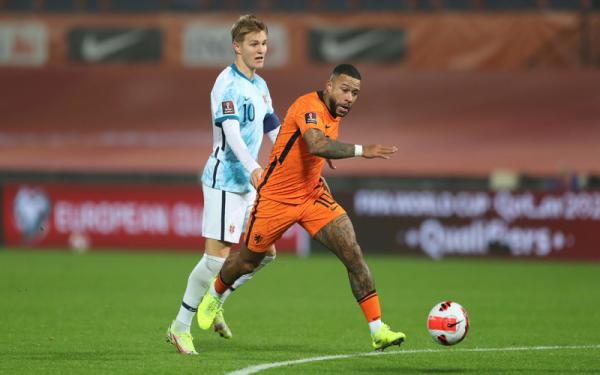 Martin Odegaard vs Memphis Depay Dua pemain bernomor 10 Belanda dan Norwegia, Memphis Depay (kanan) dan Martin Odegaard beraksi ketika timnya bertemu dalam laga Kualifikasi Piala Dunia 2022 di Stadion Feyenoord, Rabu (17/11/2021). (Foto: REUTERS/Pascal Rossignol)