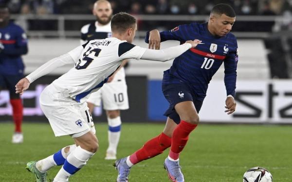 Striker Timnas Prancis, Kylian Mbappe (kanan) berusaha melewati hadangan pemain Finlandia, Leo Vaisanen, dalam laga Kualifikasi Piala Dunia 2022 di Stadion Olimpiade Helsinki, Rabu (17/11/2021). (Foto: REUTERS/Lehtikuva)