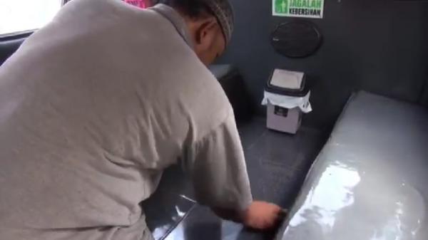 ANGKOT UNIK SUBANG2 Iswan Subarsah, pemilik angkot, membersihkan lantai keramik di angkotnya. (Foto: iNews/YUDY HERYAWAN JUANDA)