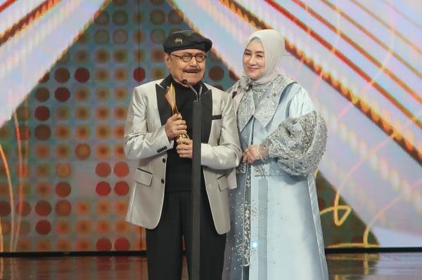 Penyanyi senior Muchin Alatas meraih piala di Anugerah Dangdut Indonesia (ADI) 2021 
