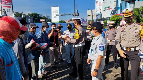 OPERASI ZEBRA LODAYA HELM GRATIS1 Dirlantas Polda Jabar Kombes Pol Eddy Djunaedi membagikan sembako kepada warga terdampak pandemi di sela kegiatan Operasi Zebra Lodaya 2021. (Foto: Humas Polda Jabar)