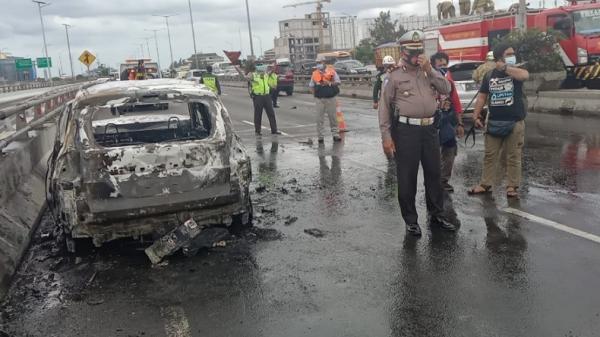 Petugas mengamankan lokasi mobil terbakar di KM 01.400 arah Tanjung Priok Jakarta Utara, Senin (29/11/2021). (Foto: TMC Polda Metro Jaya).