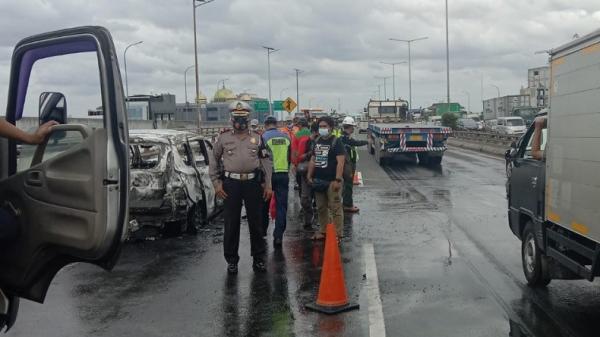 Petugas mengamankan lokasi mobil terbakar di KM 01.400 arah Tanjung Priok Jakarta Utara, Senin (29/11/2021). (Foto: TMC Polda Metro Jaya).