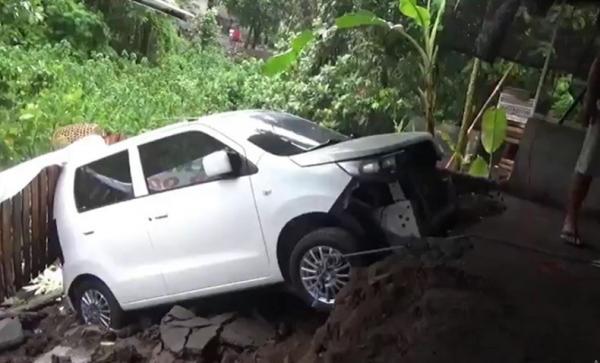 Mobil Terperosok Kota Denpasar dikepung banjir, Senin (6/12/2021). Mobil warga terperosok akibat longsor. (Foto: iNews/Aris Wiyanto)