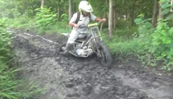 Pak guru Andik menerobos jalan berlumpur menuju sekolah tempanya mengajar. (Foto: iNews.id/Mukhtar Bagus).