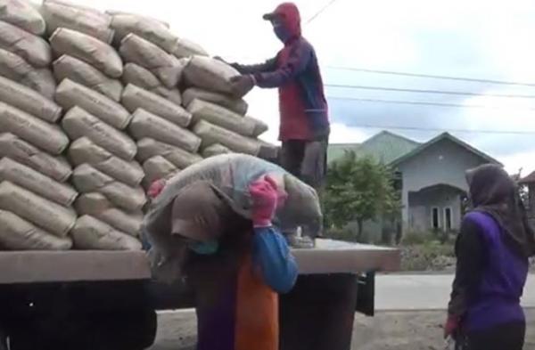 Nur Aini gadis cantik asal Kabupaten Pinrang mengangkut semen berbobot 50 kg. Dalam sehari mampu mengangkut ratusan sak. (Foto: MPI/Erwin Eka P)