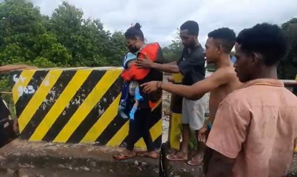 Ibu menggendong bayi nekat menyeberang jembatan ambruk di Alor, NTT. (Foto: iNews/Danny Manu)
