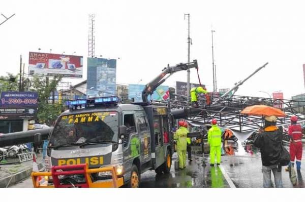 Petugas melakukan penangganan baliho yang roboh di perempatan Condongcatur, Depok roboh, Rabu (12/1/2022). (Foto: Dok BPBD Sleman)