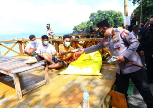 Kapolri Jenderal Pol Listyo Sigit Prabowo membagikan masker kepada warga di Maluku Utara, Jumat (14/1/2022). (Foto: ist)