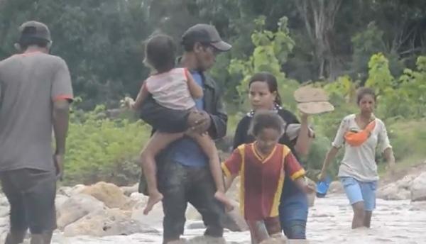 Seberangi Sungai Warga Desa Nunponi menyeberangi arus sungai yang deras. (Foto: iNews/Stevanus Dilepayong).