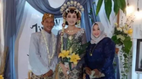 Kedua mempelai berfoto saat resepsi pernikahan. (istimewa).