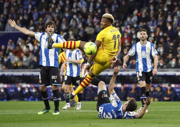 Winger Barcelona, Adama Traore Winger Barcelona, Adama Traore terjungkal oleh aksi pemain Espanyol, Adria Pedrosa dalam laga Liga Spanyol 2021/2022 di Stadion RCDE, Senin (14/2/2022). (Foto: REUTERS/Albert Gea)